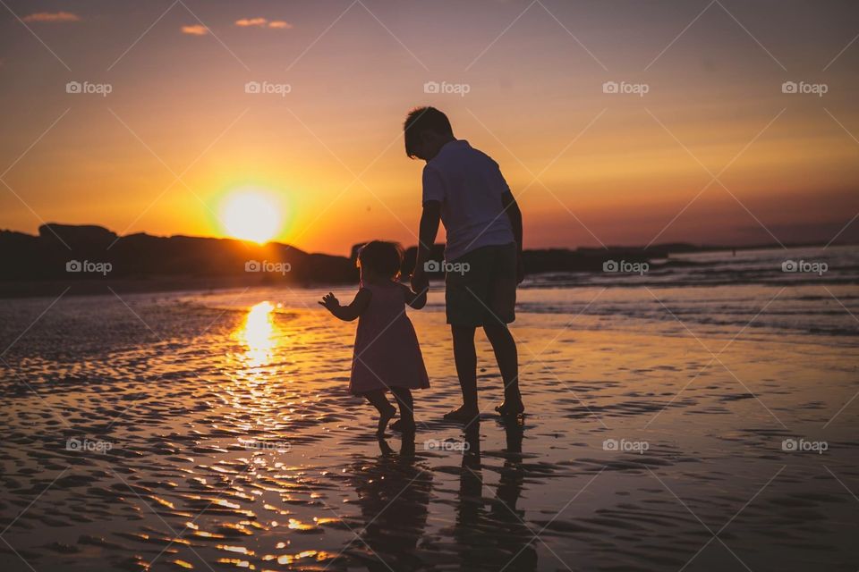 Kids holding hand at sunset