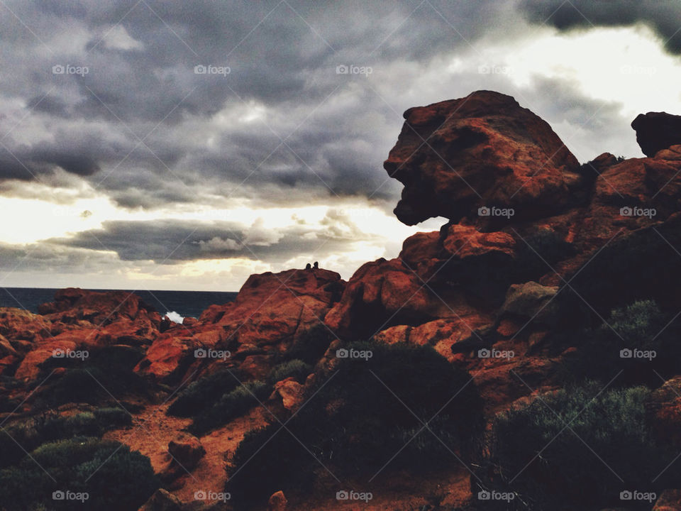 Stormy sky over red rocky coast