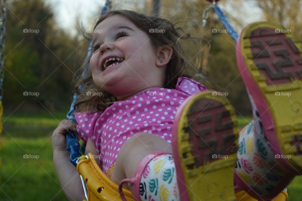 Close-up of a happy girl having fun on swing