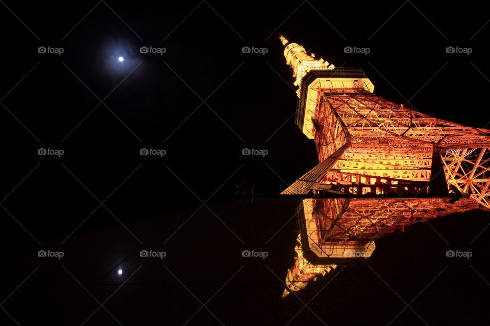 Symmetrical reflection of Tokyo tower and full moon in  clear weather day