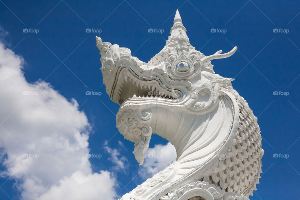 Thai naga head sculpture in blue sky background