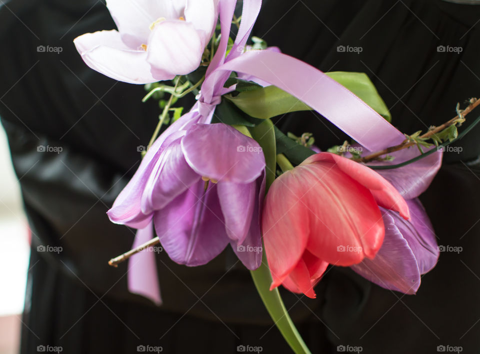 Dreamy Fairy Flower crown with red and lavender hanging next to little black dress with satin sash closeup detail getting ready for celebration conceptual background