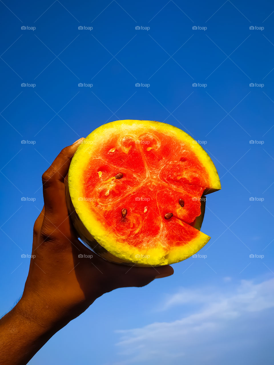 A boy with half a watermelon on a blue background