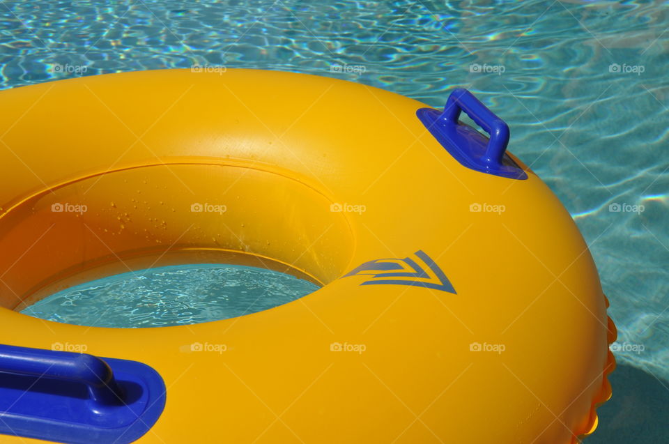 Yellow pool float / ring in a swimming pool.