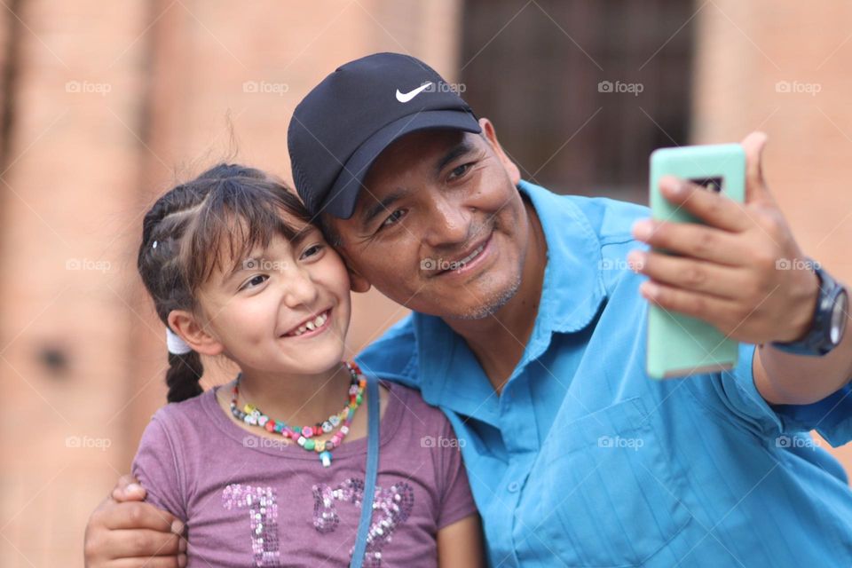 Father and daughter are taking a selfie together