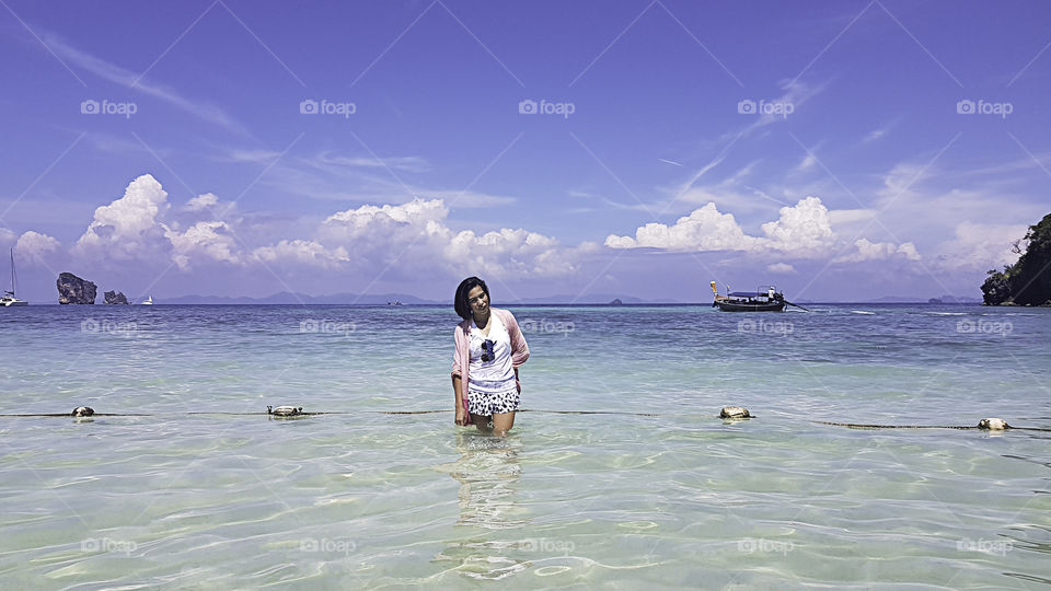 Portrait Asian woman Standing in the sea of clear skies at krabi in Thailand