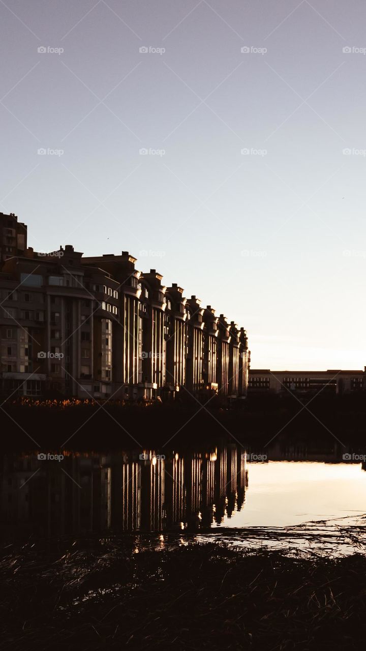 Reflection of building in the lake at sunset light.