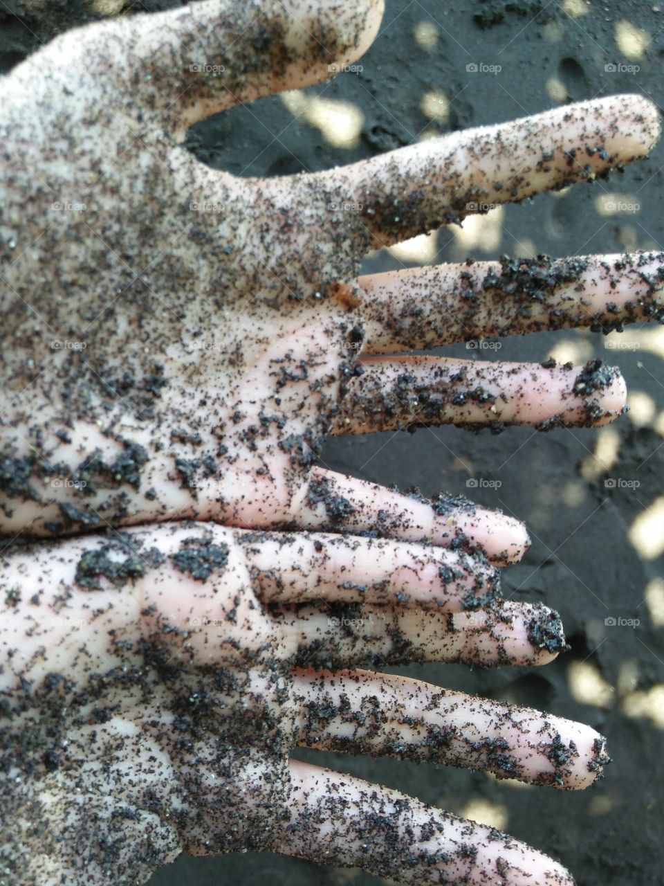 hands with black sandy