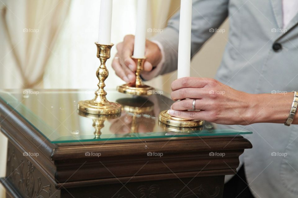 hands hold candles during a wedding
