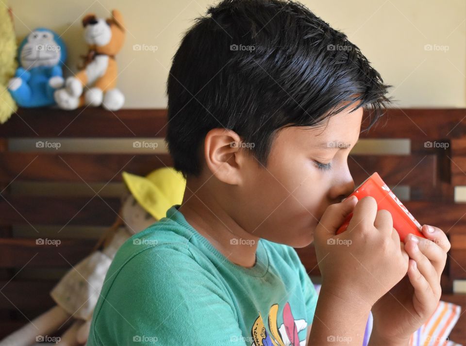 boy drinking milk at home in morning