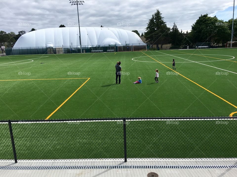 Family playing on a soccer field