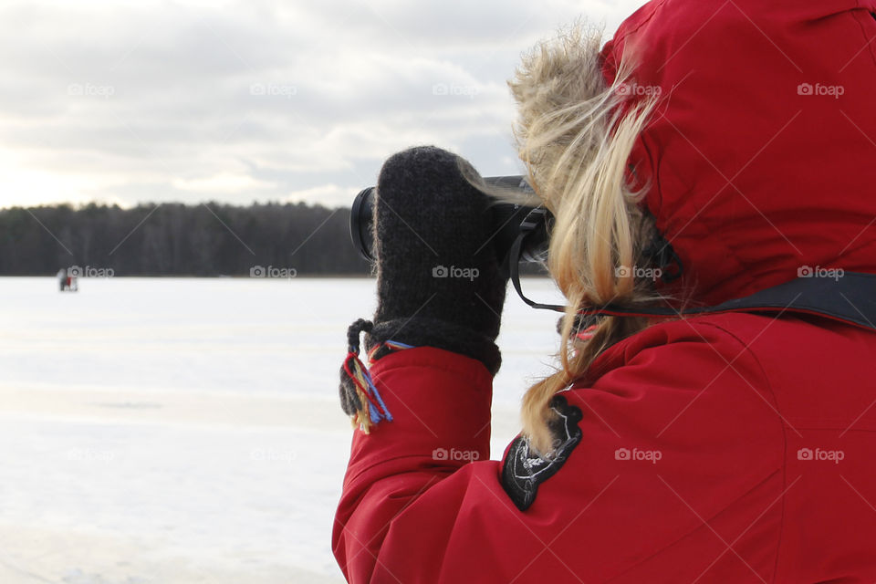 Photographer in red - shooting winter landscape 