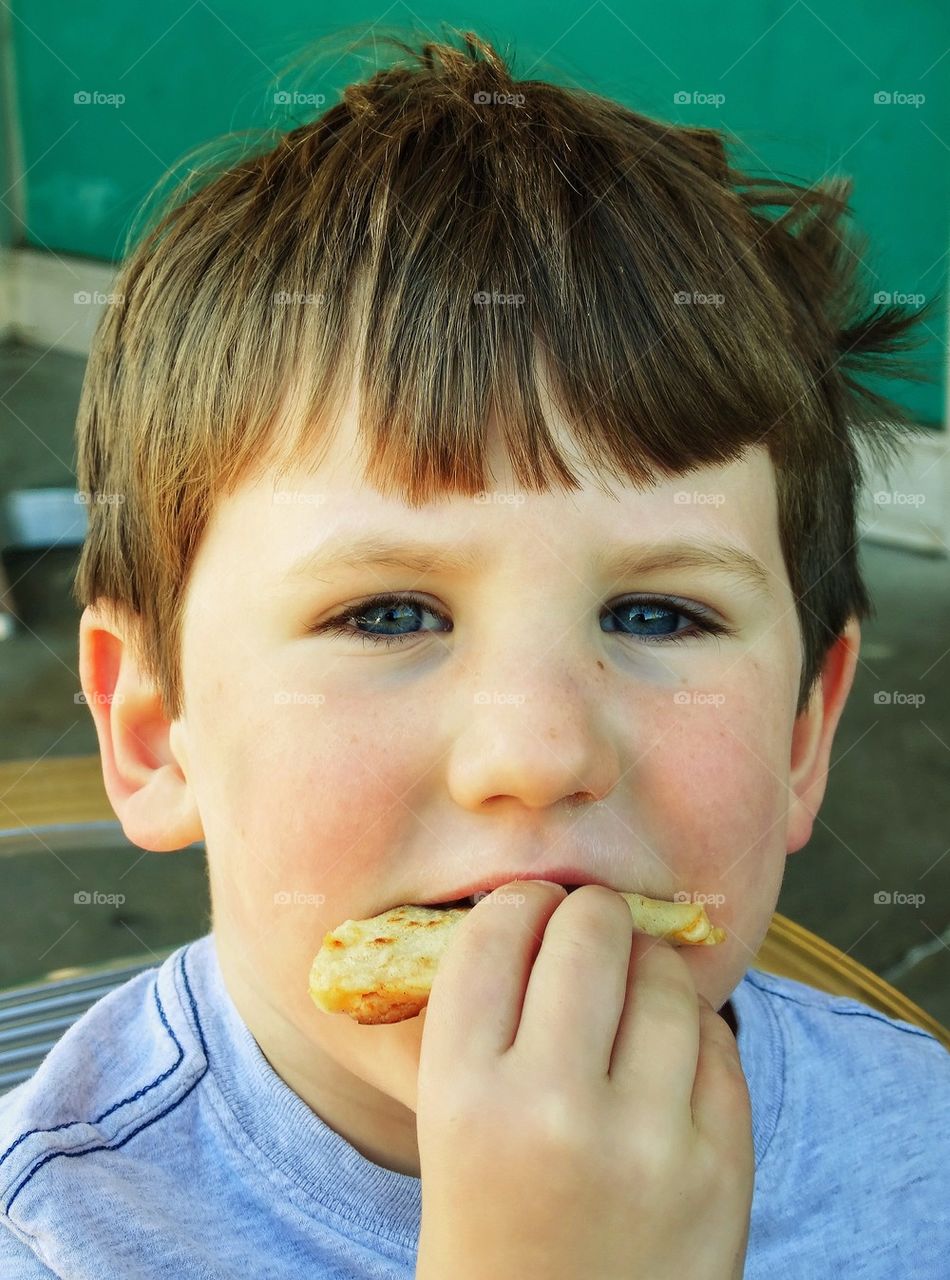 Young Boy Eating A Snack
