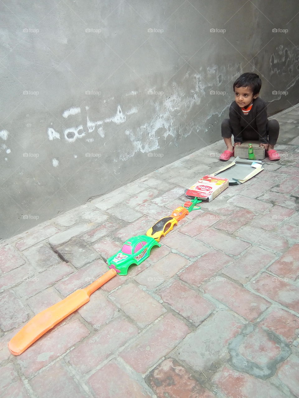 A little boy trying to make a long train.