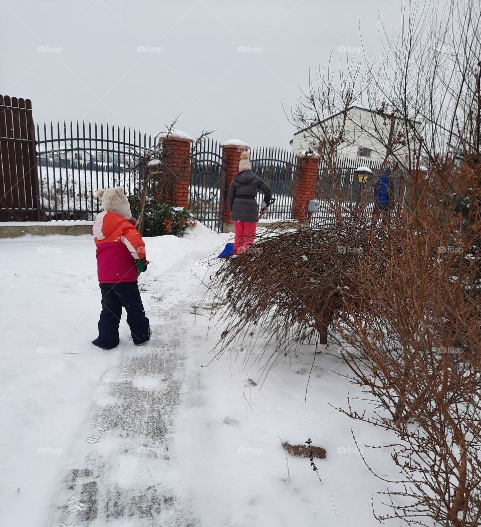 Kids clearing snow from the yard