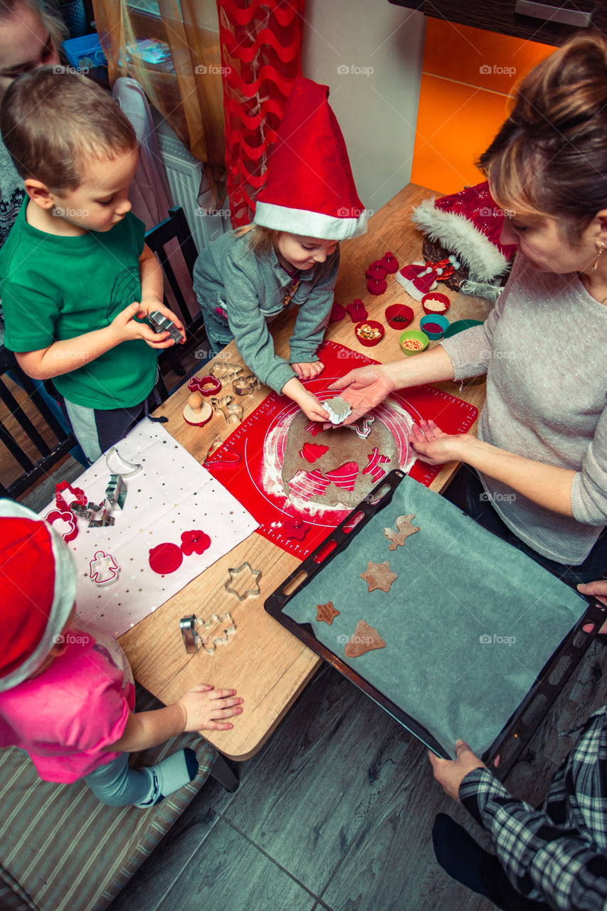 Baking Christmas cookies. Christmas gingerbread cookies in many shapes decorated with colorful frosting, sprinkle, icing, chocolate coating, toppers, put on table. Baking traditional cookies. Family celebrating Christmas. Baking at home