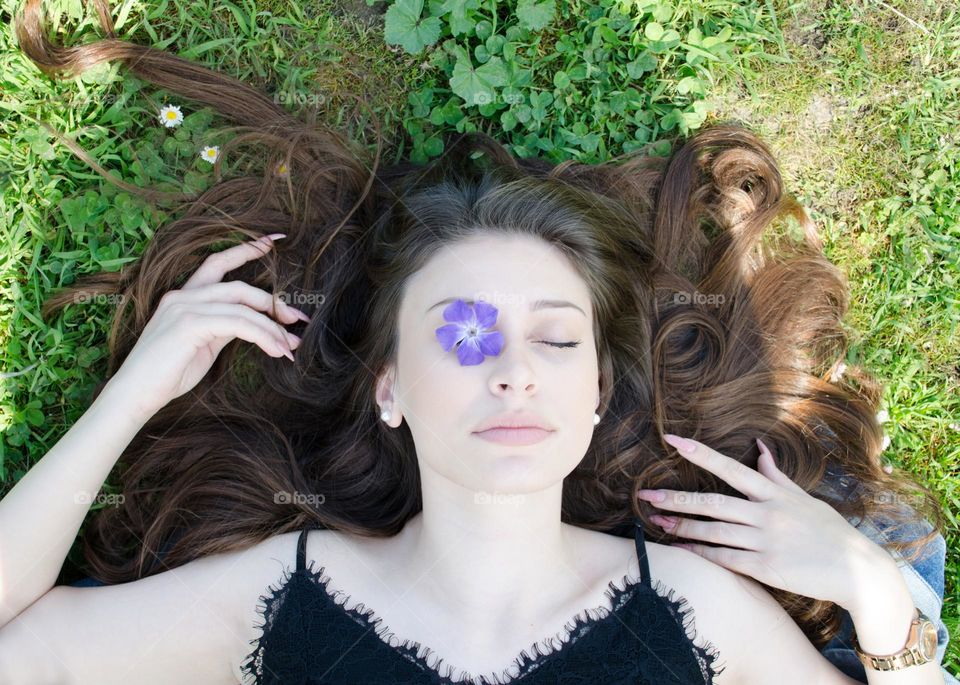 Portrait of a Beautiful Young Girl on Background of Daisies