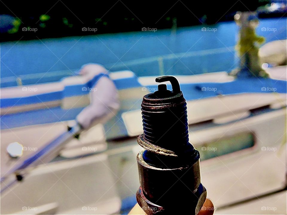 A dark metal valve in focus set against the slightly blurred backdrop of a white and turquoise deck of a boat in the waters of the East River at Newtown Creek in LIC, Queens, NY. A simple theme but beautifully photographed. 2021. Hypnotic Productions