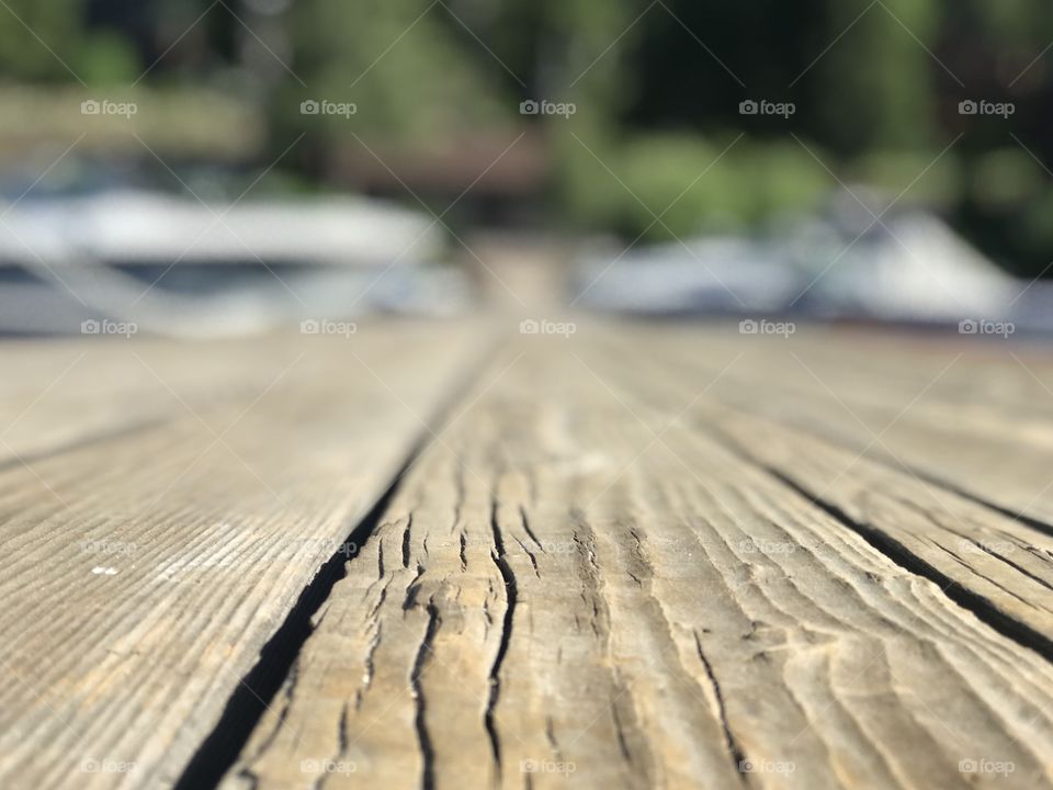 A closeup of the weathered wood grain of an empty dock on the lake. Character built with time and wear. 