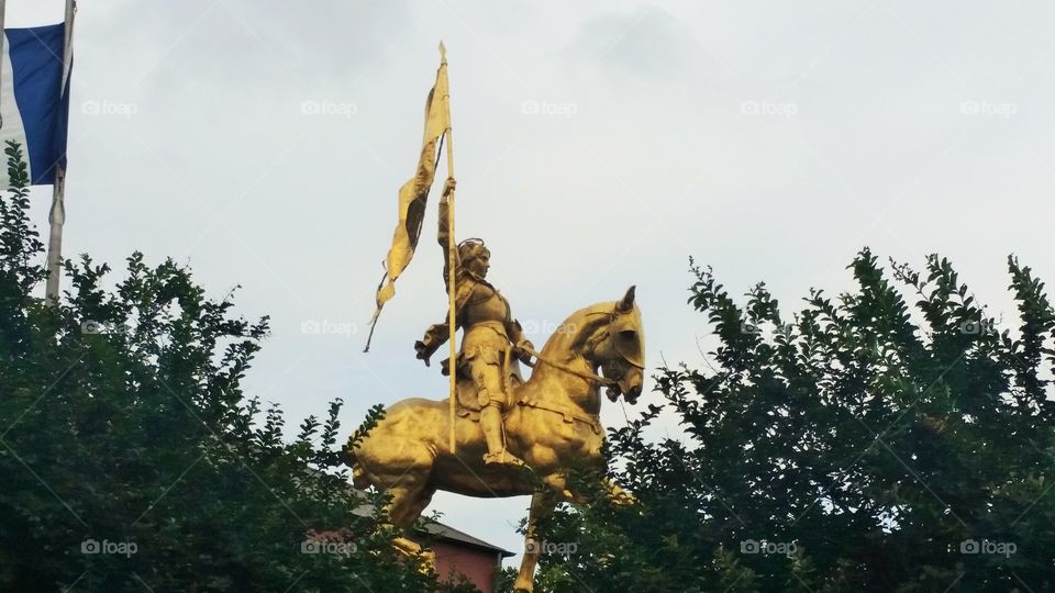 Monument statue of man on horse holding flag