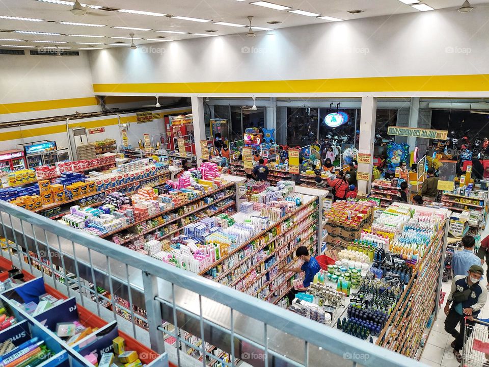 The view of the first floor of a supermarket from above, the goods are displayed neatly