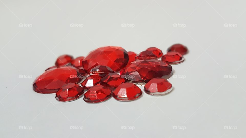 Red gemstones over white background