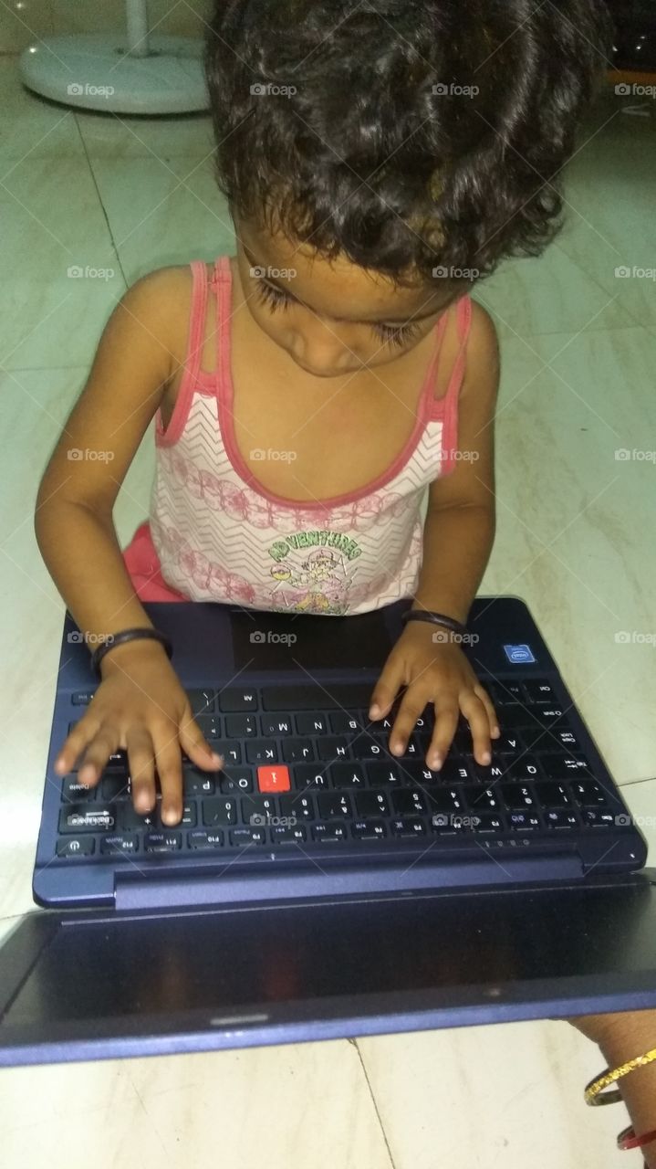 child operating laptop playing games