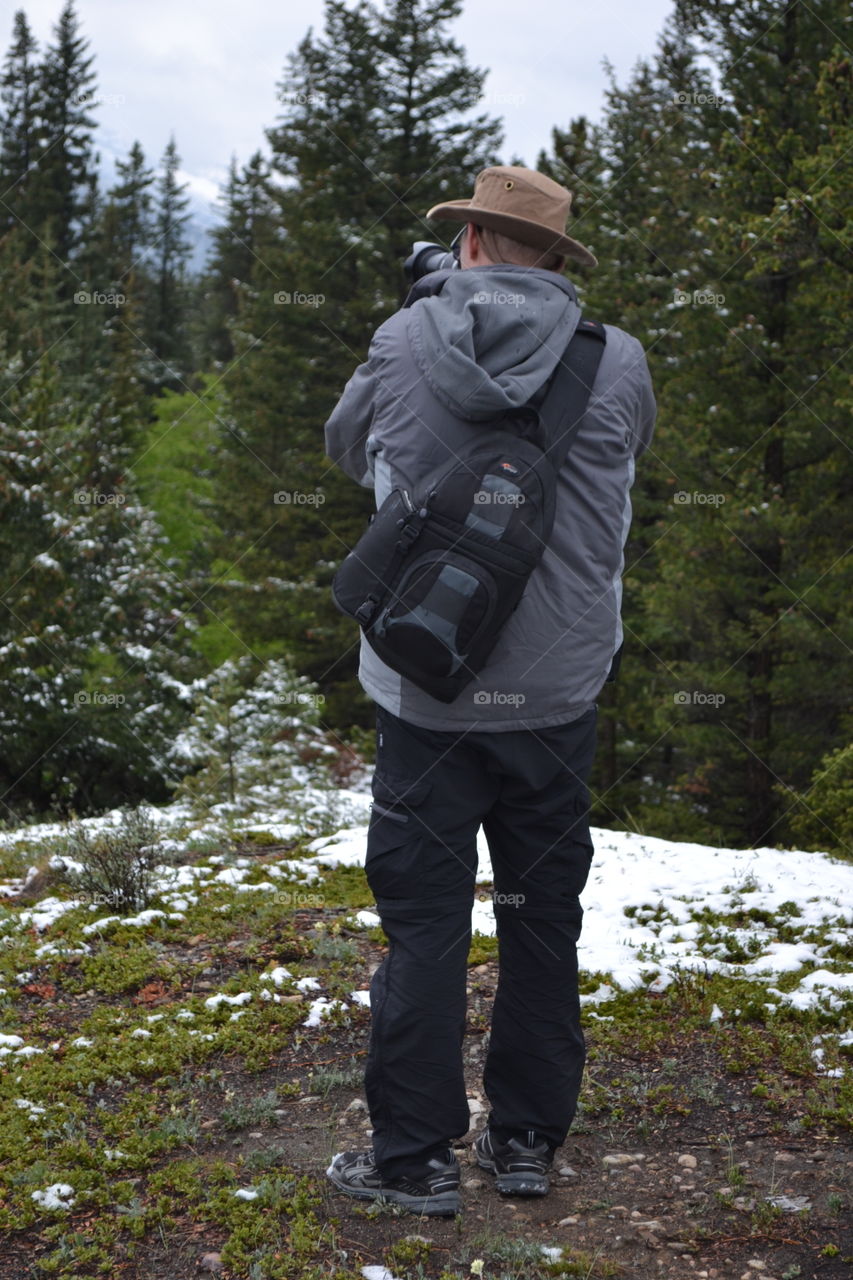 Male photographer photographing nature landscape, full body, camera