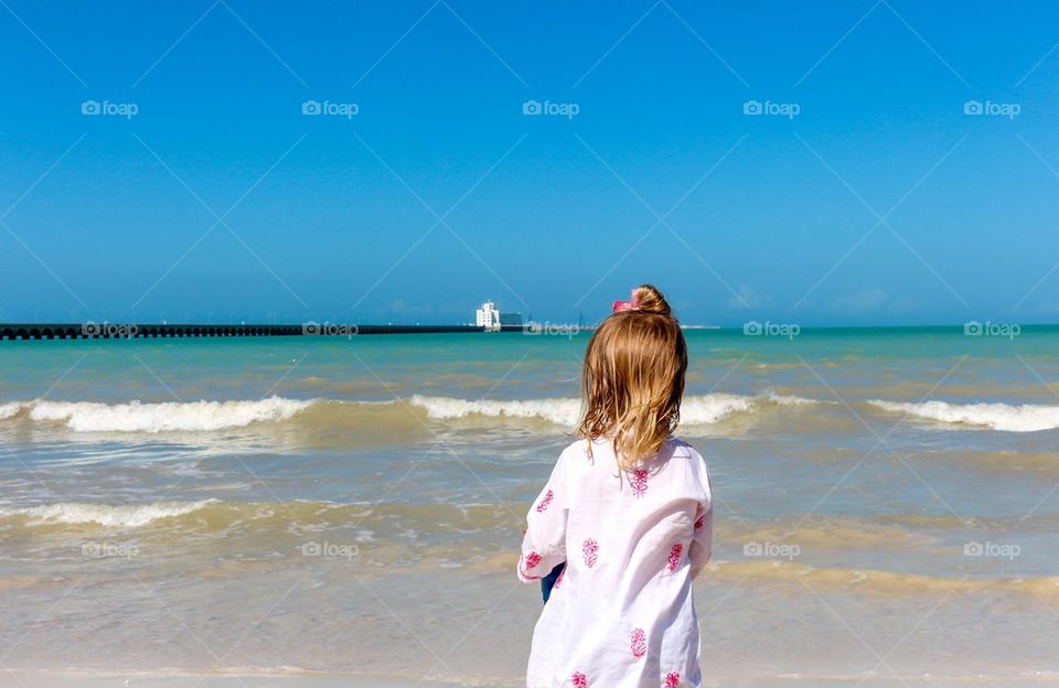 Child staring at the ocean