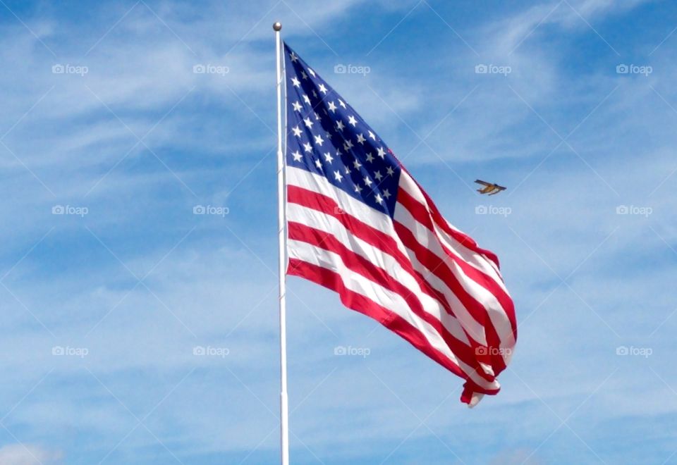 Flag flying with plane in the background