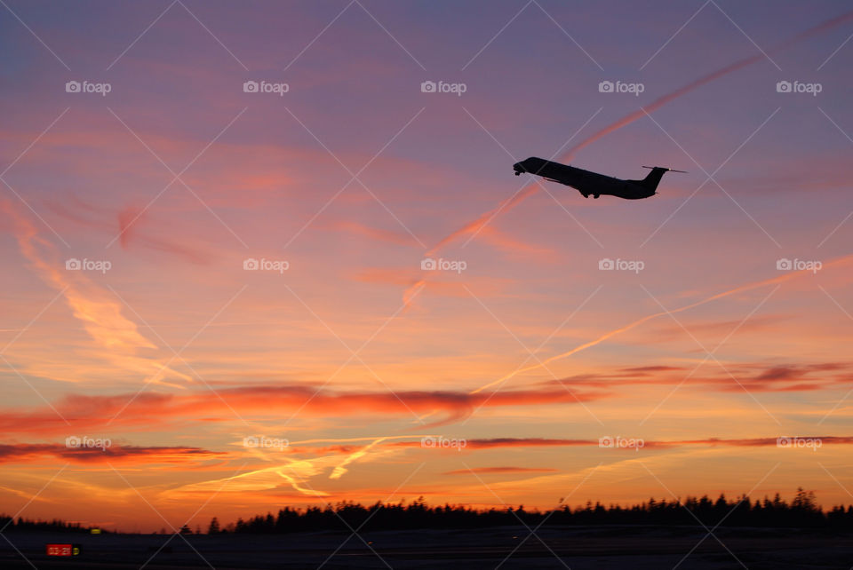 Silhouette of airplane during sunset