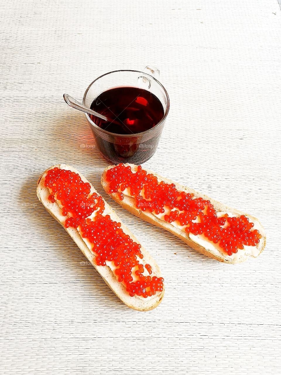 Breakfast.  A cup of tea and two rolls with butter and red caviar