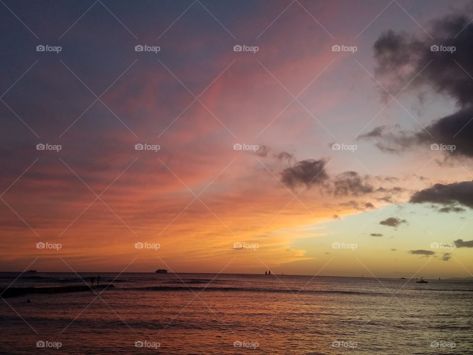 the sun sets over Waikiki beach