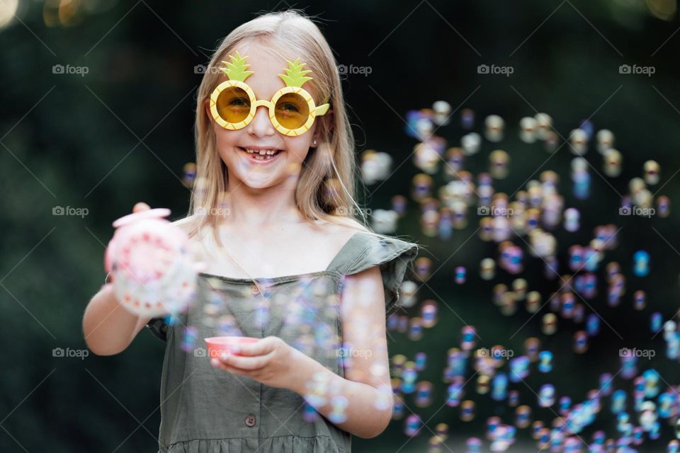 Happy Caucasian little girl with soap bubbles 