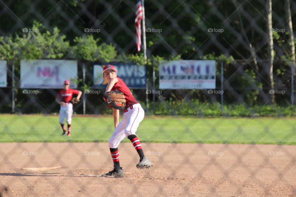 Youth baseball player pitching during game 