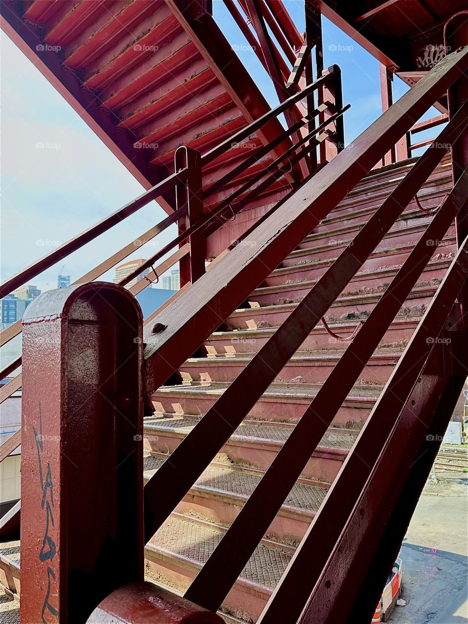 This is the red metal staircase of the “Pulaski Bridge” at “Newtown Creek” in LIC, Queens with its “Bauhaus” inspired elements: use of prime color, functional design and use of strong simple geometry. 2024. Hypnotic Productions