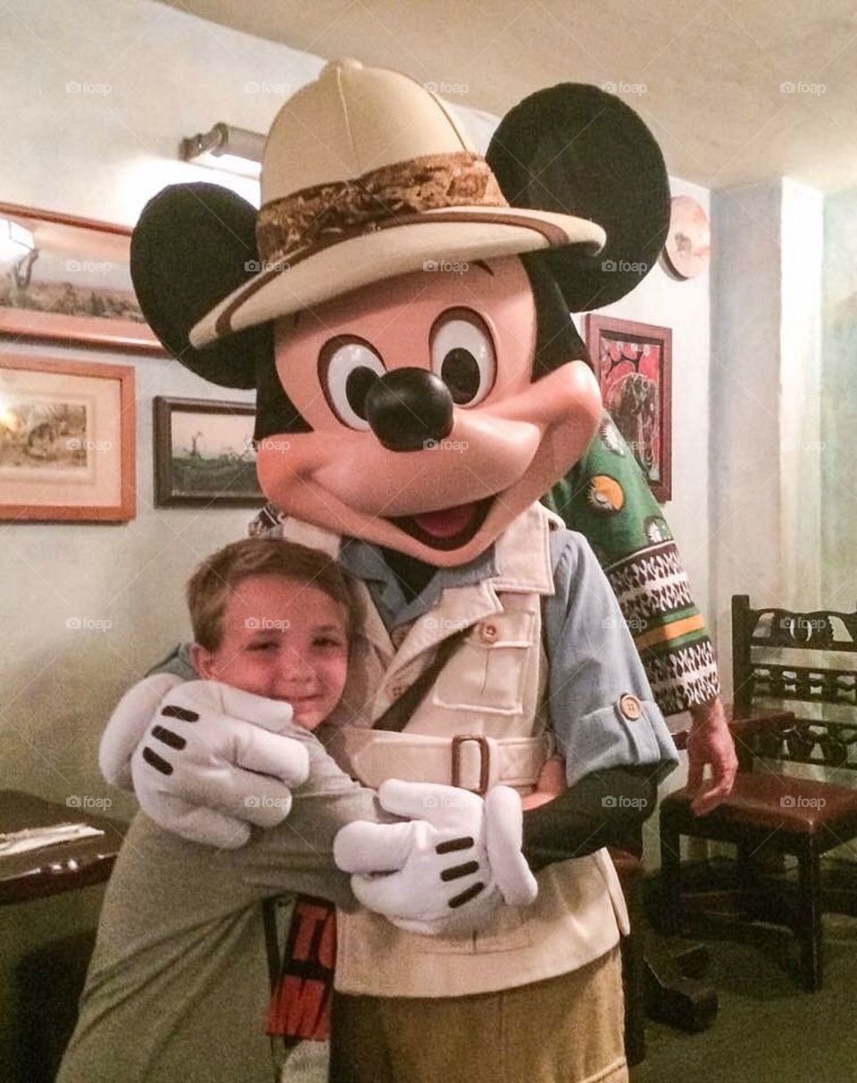 Boy embracing micky mouse