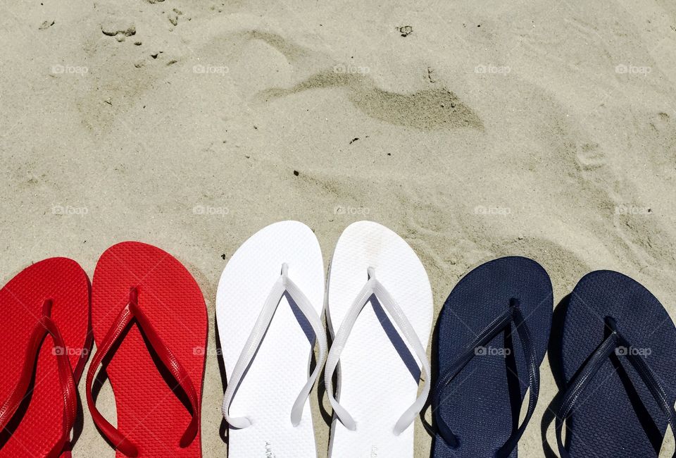 Flip flop sandals. Red white and blue flip-flops on the sand room for your text