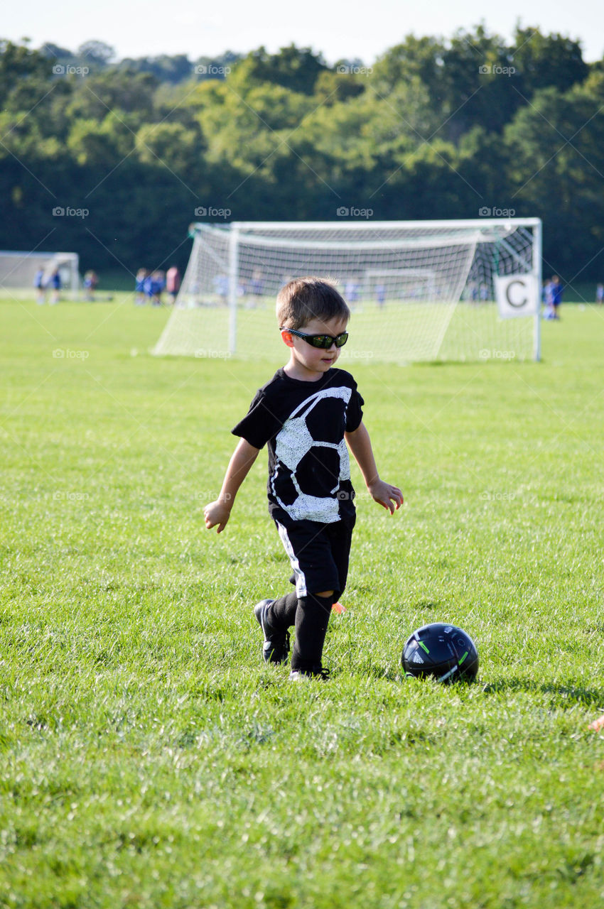Young boy playing soccer on a field