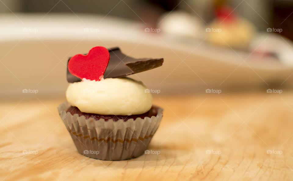 Chocolate cupcake with red chocolate candy heart and white chocolate frosting 