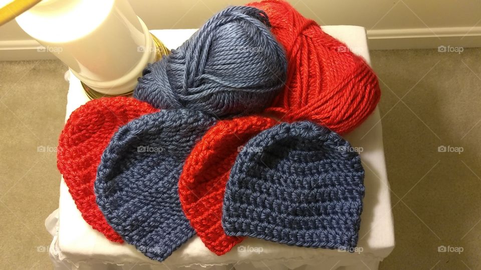 Crocheted hats and yarn, red and blue