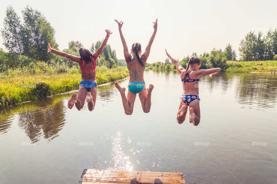 Girl are jumping, swimming in the lake