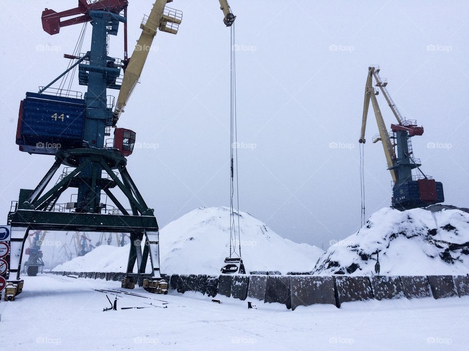 The winter time in the Izmail sea commercial port. The terminal with coal. Snow. Cargo crane. Industrial landscape. 