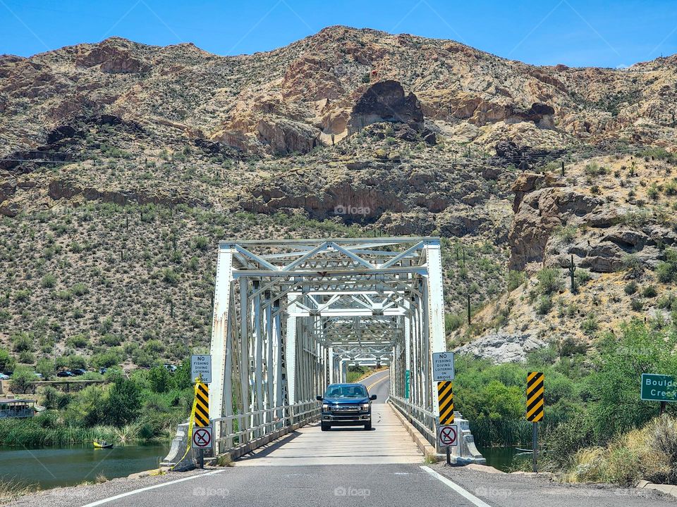 A narrow bridge over a lake outlet allows for one direction traffic at a time