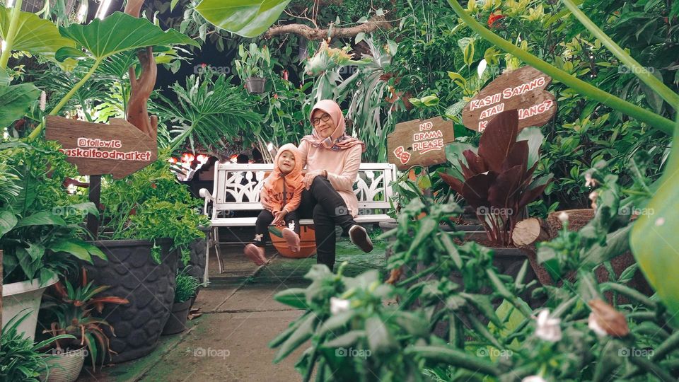 mother and her daughter in the middle of the garden.