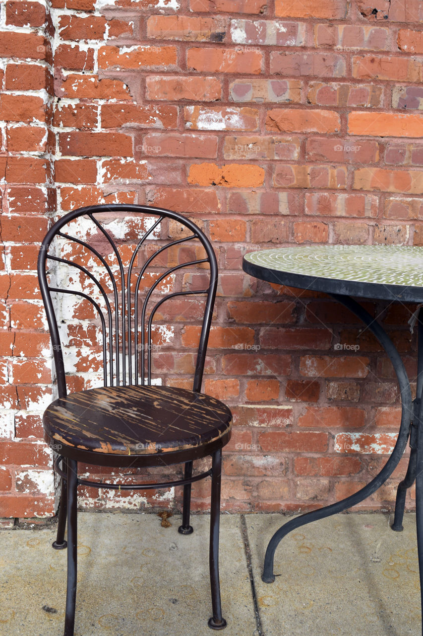 Table and Chair in Front of Brick 
