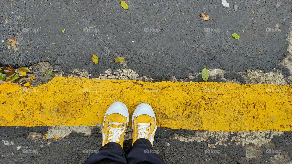 Yellow shoes stand on yellow line