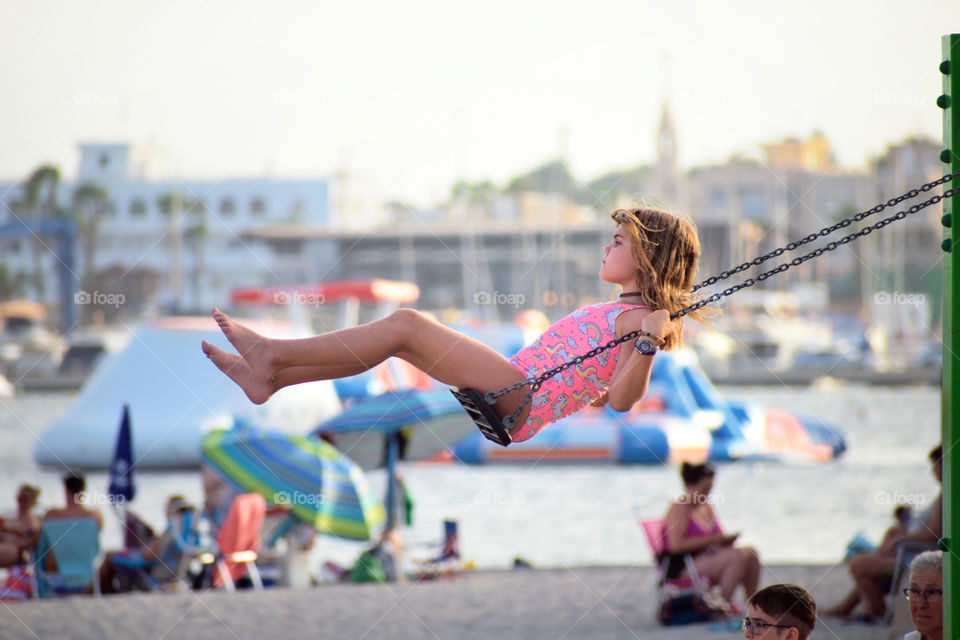 Little girl on swing seat at playground