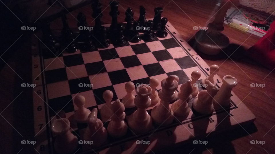 Playing chess game besides a candlelight