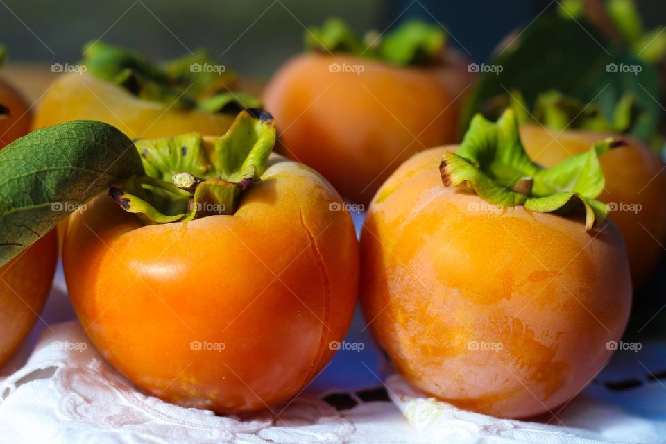 Close up of a ripe organic Kaki Japanese Persimmon.  Beautiful sweet, healthy and delicious dessert